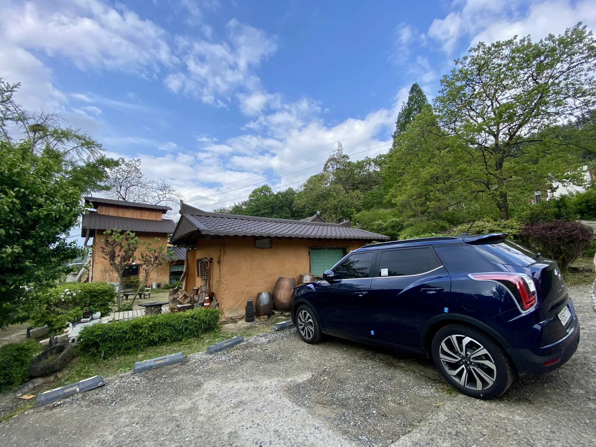 푸른 하늘 아래 고즈넉한 한옥과 네이비 SUV · 2021-05-01