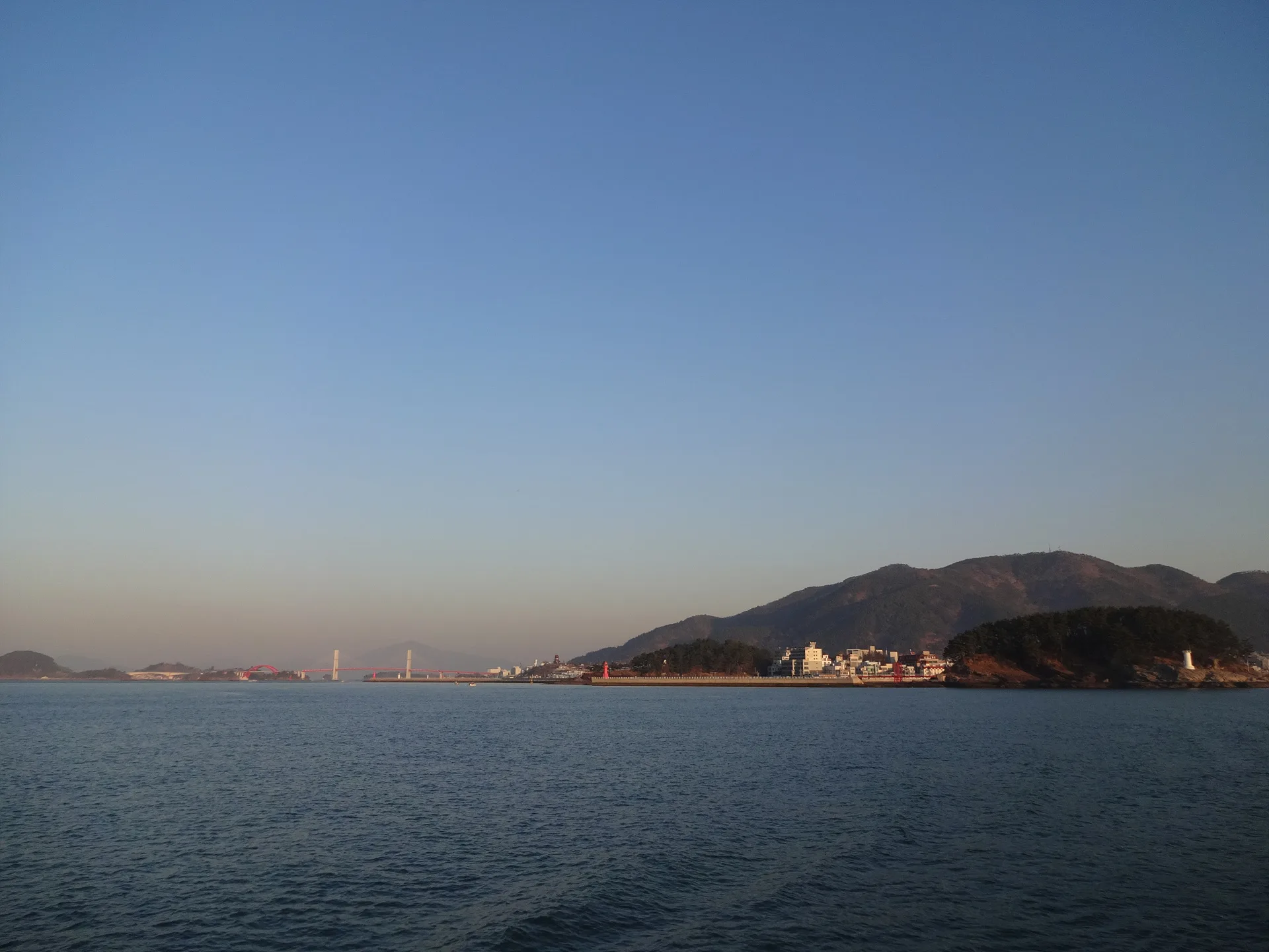 푸른 바다 너머로 펼쳐진 고요한 해안 마을 풍경 · 사량도, 통영시, 경상남도, 대한민국 · 2014-03-22