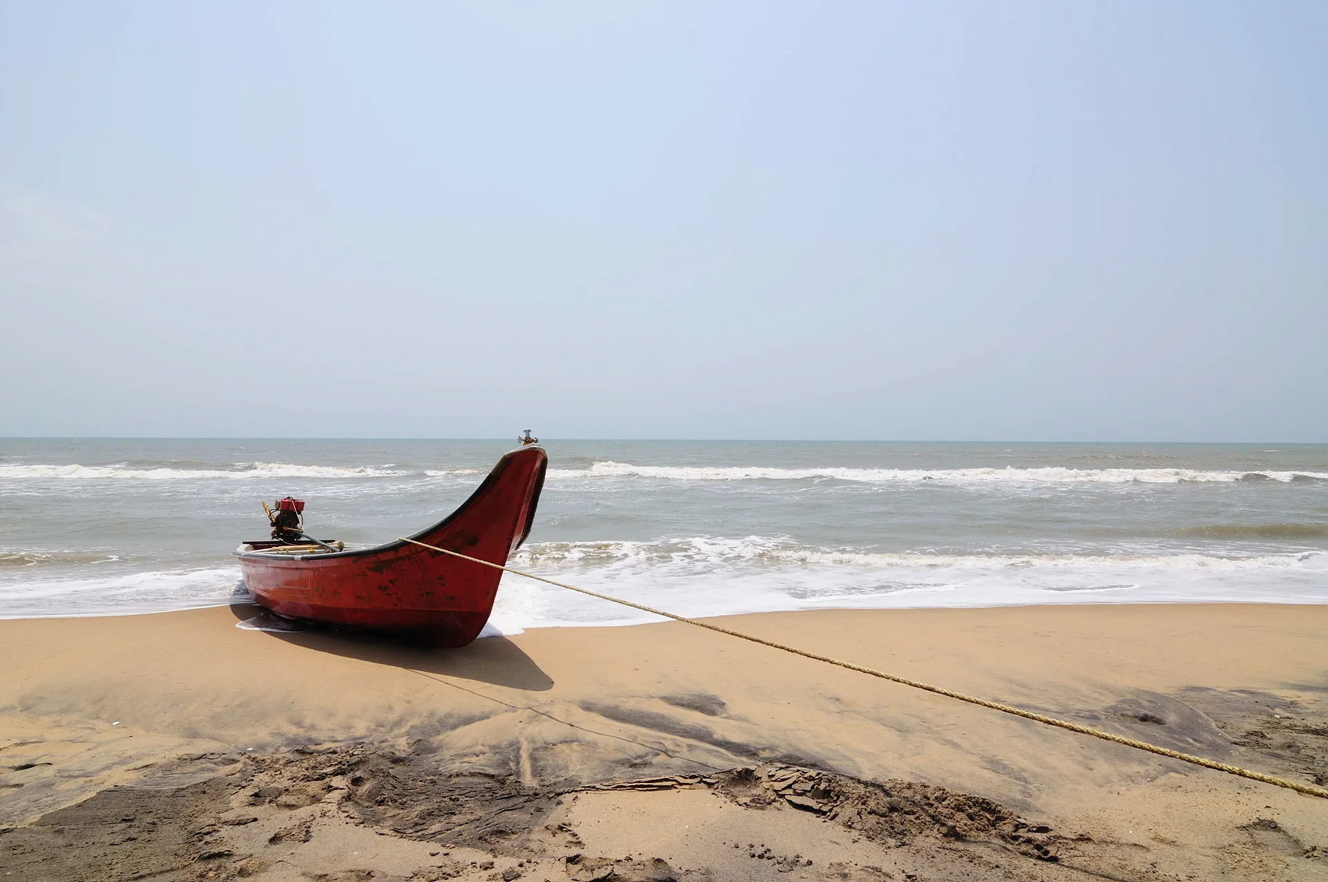 해변 위에 정박한 붉은색 전통 낚싯배 · Mahabalipuram, 타밀나두, 인도 · 2009-04-24
